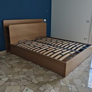 Letto contenitore in legno con testiera attrezzata
